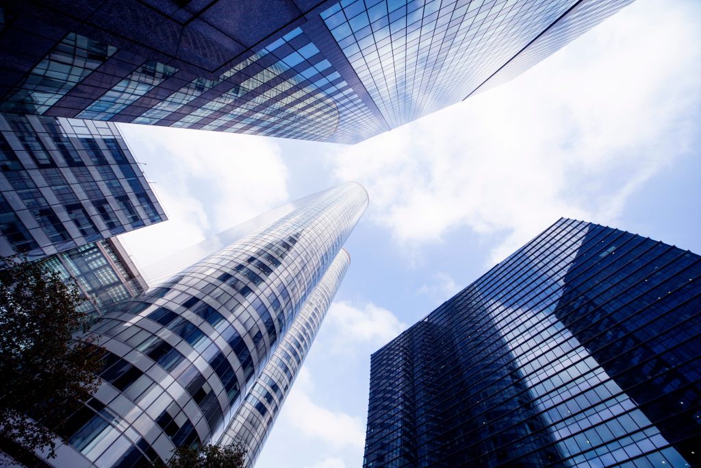 Upward view of innovative skyscrapers under a bright sky in La Défense, Paris.