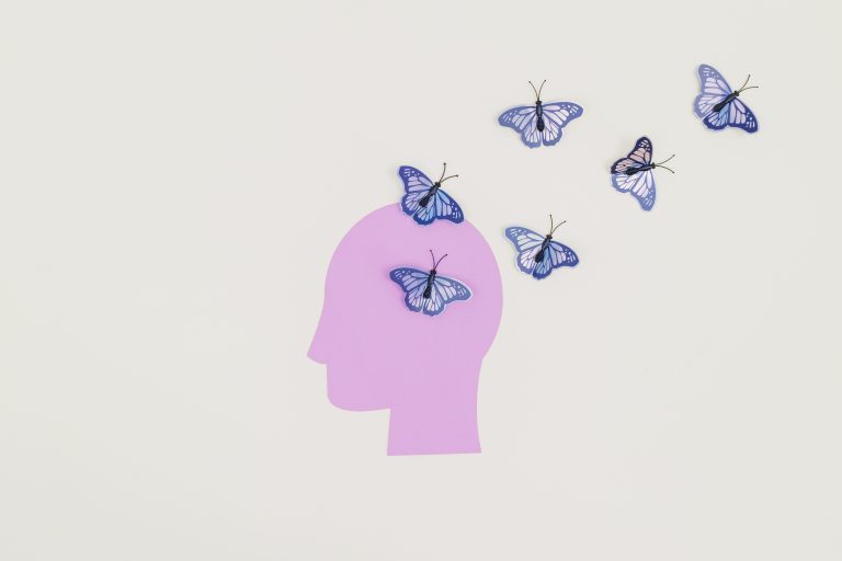 Abstract art of butterflies emerging from a silhouette head representing imagination and freedom.